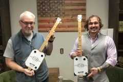 Barry-McCue-and-Devon-Mickey-holding-the-homemade-guitars-scaled-e1619718611260